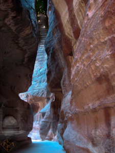 A composite painting featuring one of Petra, Jordan's slot canyons with stairway rising from the back to the night sky constellation of Orion. Canyon walls carved with angel on right side and geometric abstract deity on left with pathway in the center.