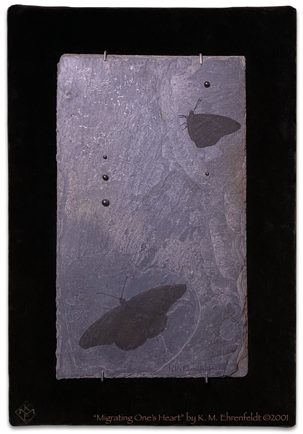 Dark monarch butterfly on etched heart in the weathered slate tile, and another monarch above; with hematite droplets rising and falling on the slate, with background of black velvet.
